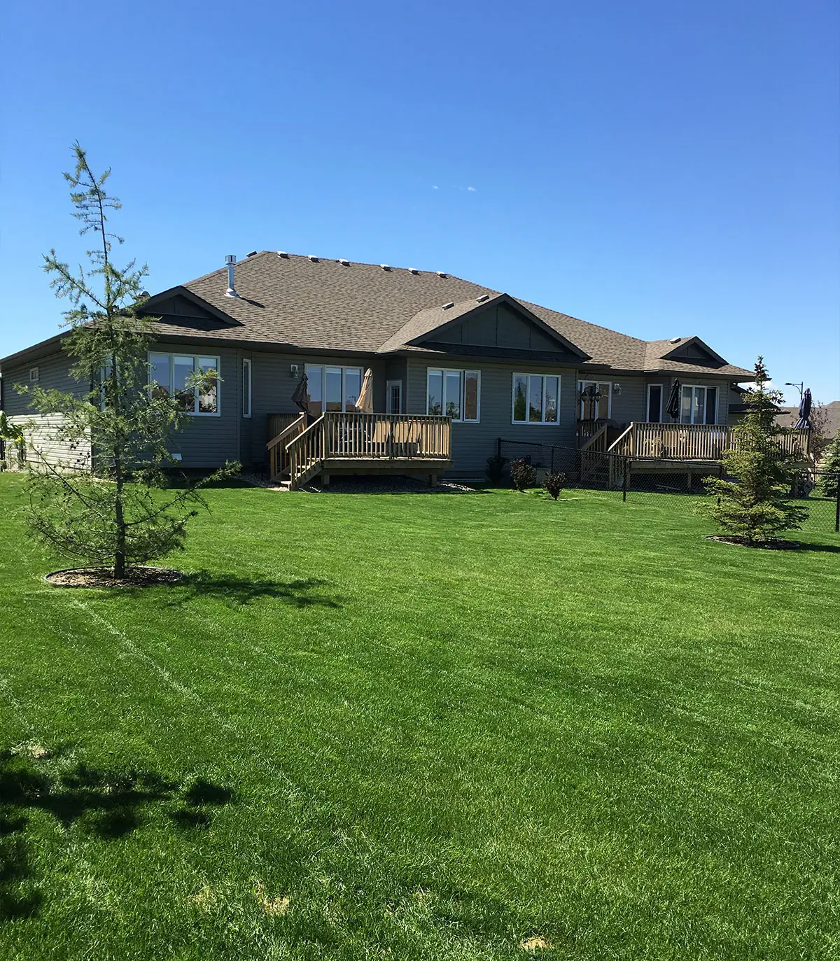 Broad backyard lawn beside a raised deck