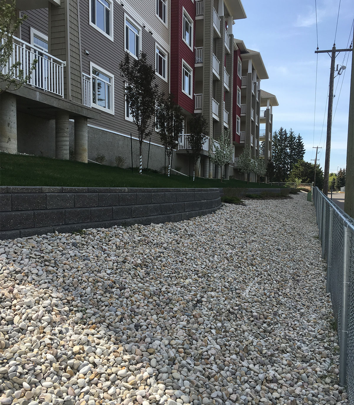 Gravel ground cover beside a retaining wall and lawn